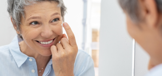 Mujer aplicándose cremas antiedad en la cara